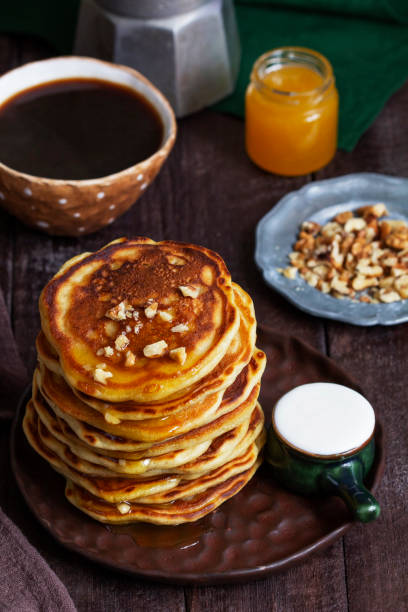 istock Apple pancakes served with honey, sour cream, nuts, tea and coffee. 1469549886