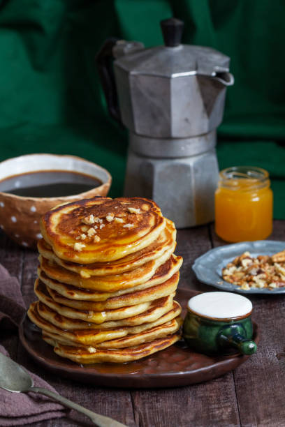 istock Apple pancakes served with honey, sour cream, nuts, tea and coffee. 1469549899