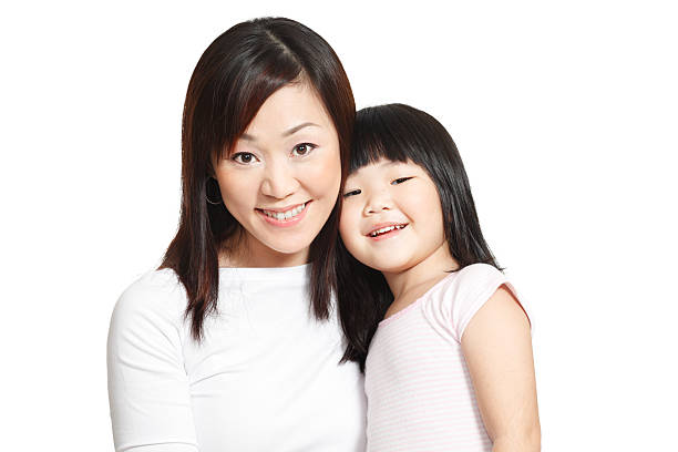 Happy shot of Chinese little girl with her young mother isolated in white