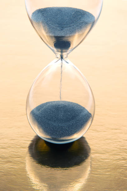 istock hourglass on a golden background. time and minute measurement 1469563949