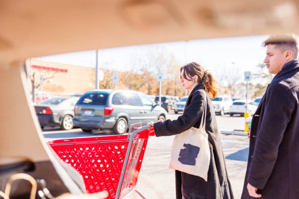 jeune famille après les courses. la femme ramène un chariot vide au magasin. - family multi ethnic group candid couple photos et images de collection