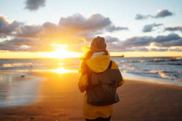istock traveler walks on  sea at sunset. 1469568267
