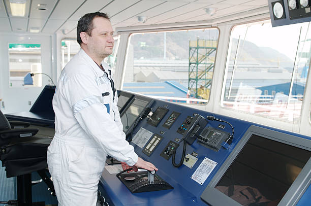 Captain looking ahead on the navigation bridge of ocean ship