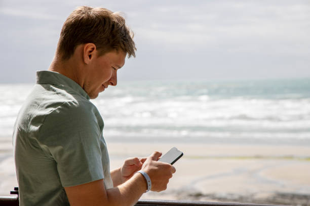 istock Young man takes break from conference to check phone on sunny coast 1469577240