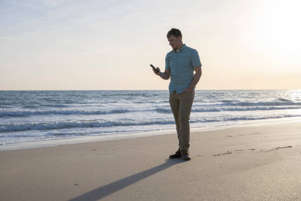 istock Young man takes break from conference to check phone on sunny coastal beach 1469578030