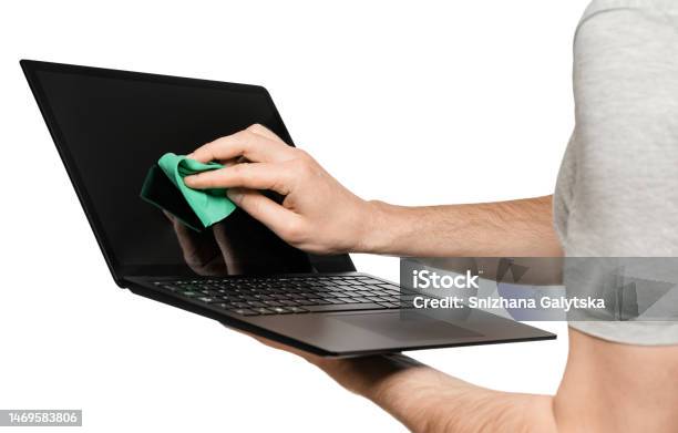 A Man Holds A Laptop In One Hand The Other Wipes The Touch Screen Isolate On A White Background Stock Photo - Download Image Now