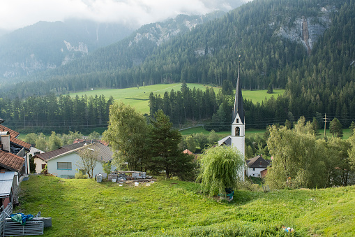 View on a small village and church in a mountain valley in canton Graubünden, south east of Switzerland