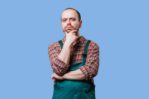 istock Meditative, handsome employee in overalls. Serious 1469602416