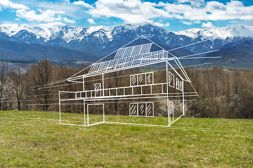 Concepts of a dream house drawn onto a grassy field with woods and mountains in the background