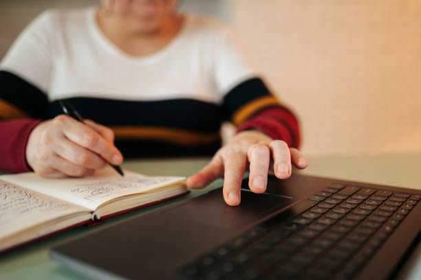 istock E-Student in Action Close-Up of a Woman Taking Notes on a Notebook While at Home 1469603027
