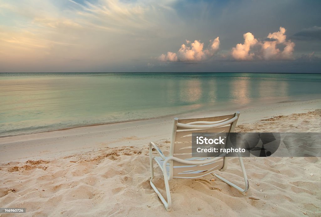 Chair on Eagle Beach in Aruba Morning light illuminates fading storm clouds over Eagle Beach in Aruba. Aruba Stock Photo