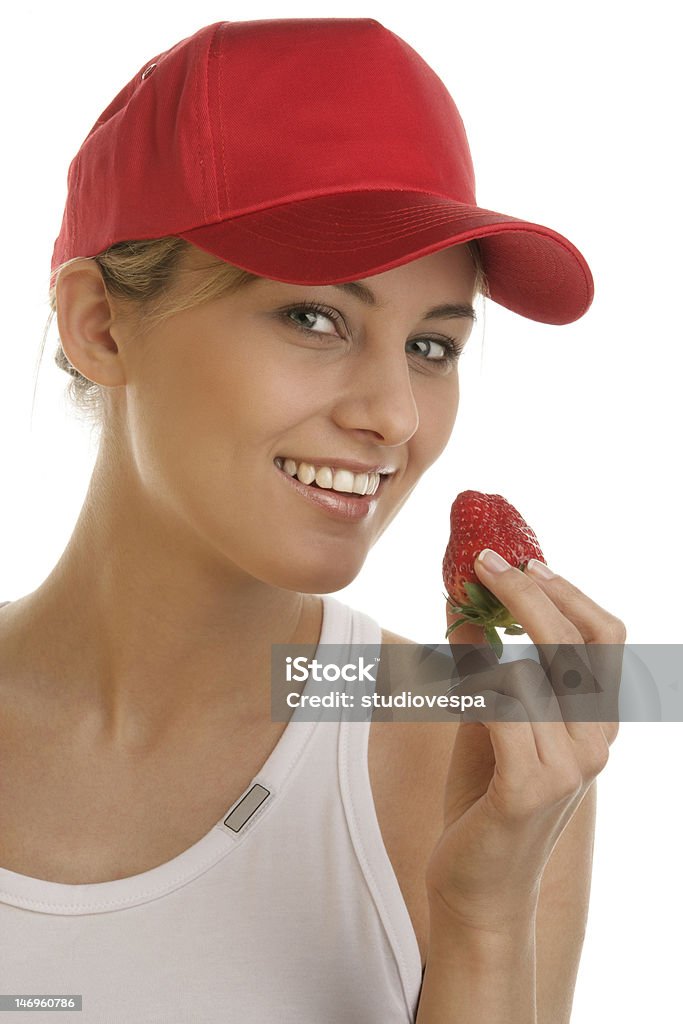 イチゴを食べる人の若い女性 - 野球帽のロイヤリティフリーストックフォト