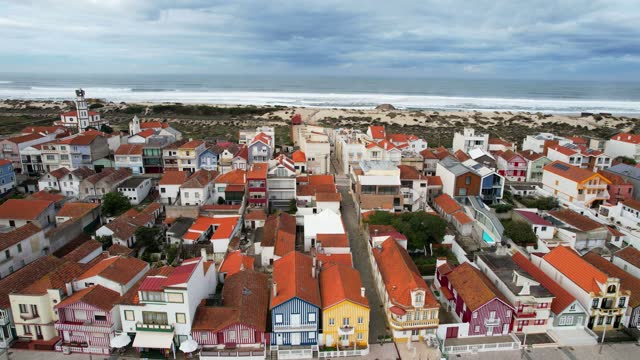 Aerial dolly left of colorful houses on Costa Nova Beach. Aveiro, Portugal