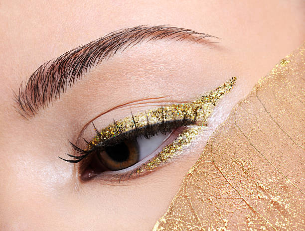 Studio shot of a beautiful woman with eyes closed and gold eye makeup