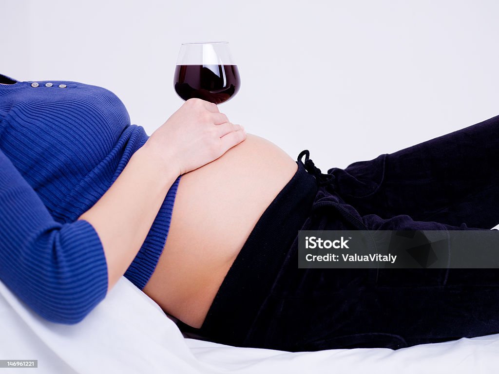 glass of wine on the stomach Pregnant woman with a glass of wine on the stomach Alcohol - Drink Stock Photo