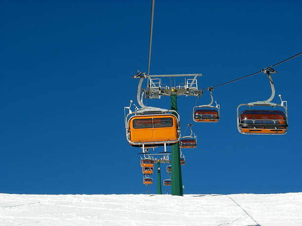 orange skiers on chairlift stock photo