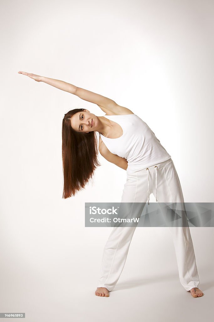 Donna Yoga nella posizione del triangolo (Trikonasana - Foto stock royalty-free di Abbigliamento