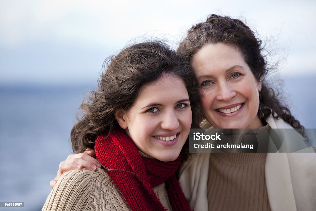 Portrait of smiling mother and daughter at the seaside A portrait of a mother and her daughter on the beach 50-59 Years Stock Photo