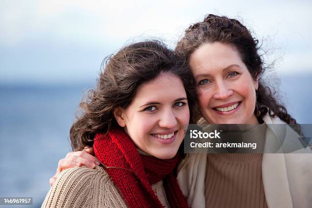 Portrait Of Smiling Mother And Daughter At The Seaside Stock Photo - Download Image Now