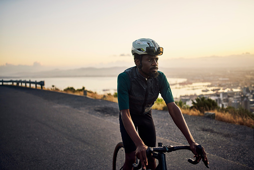 Fitness, thinking and black man cycling on the street for exercise, training and race in Spain. Health, sports and African athlete on a bike for a workout, sport and cardio on the road with vision