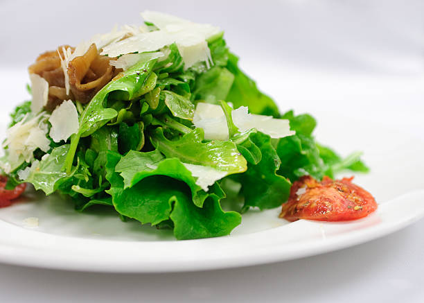arugula salad, chef prepared with caramelized onions, tomato and grana padano cheese.