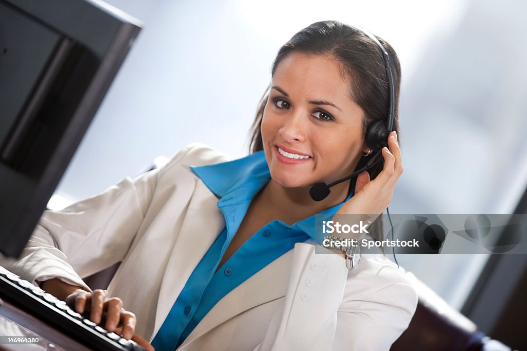 Hispanic Business donna con cuffie e sorridente - Foto stock royalty-free di 30-34 anni