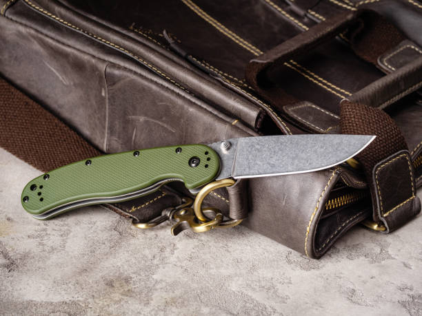 istock Green folding EDC knife near a vintage leather bag 1469646901