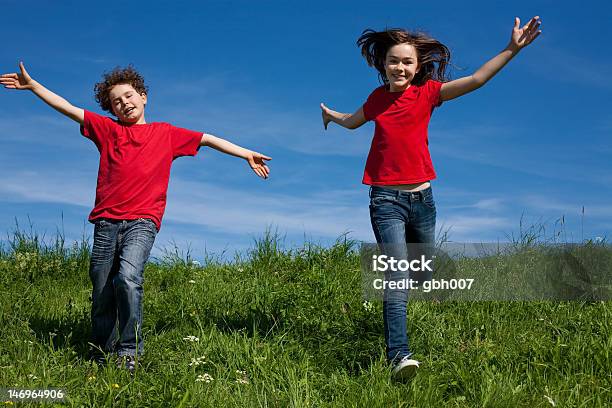 Niños Correr Saltar Al Aire Libre Frente A Cielo Azul Foto de stock y más banco de imágenes de 12-13 años