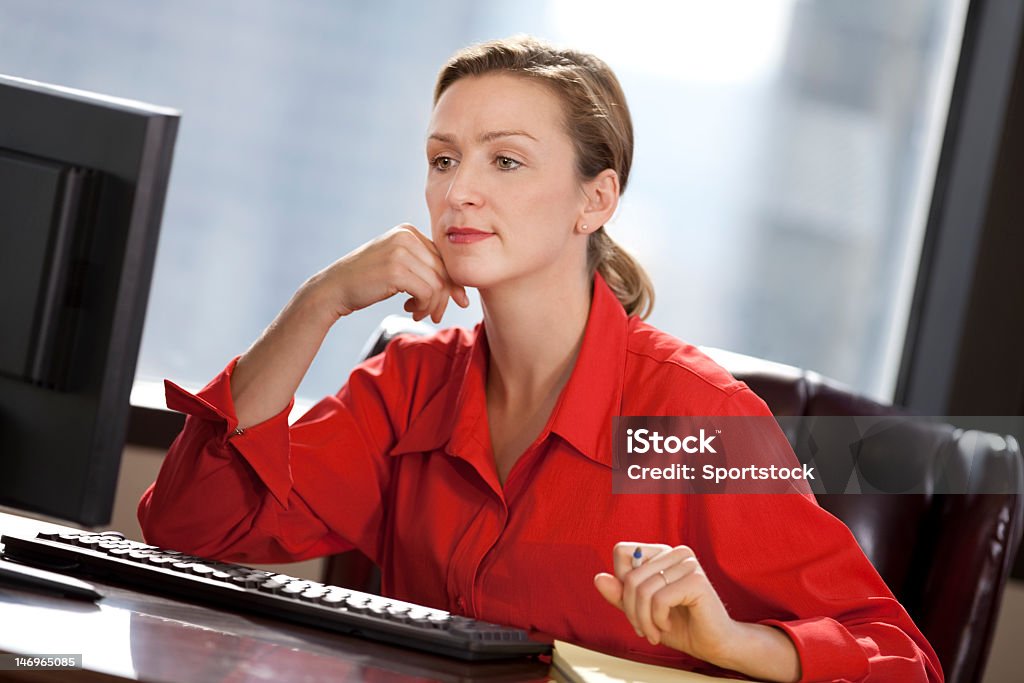 Mulher de Negócios jovem sentado no escritório olhando para computador - Royalty-free Vermelho Foto de stock