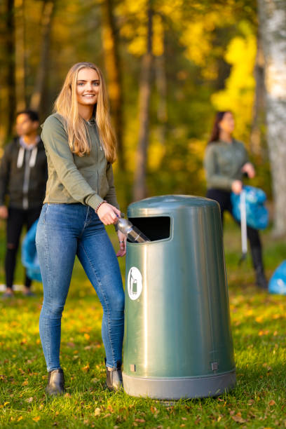 istock Smiling young woman putting bottle in garbage bin 1469652810