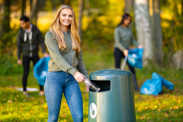 istock Smiling young woman putting bottle in garbage bin 1469652866