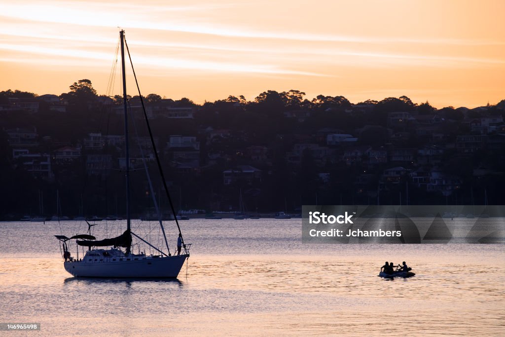 Tramonto e Yacht sulla Spiaggia di Manly Cove - Foto stock royalty-free di Attraccato