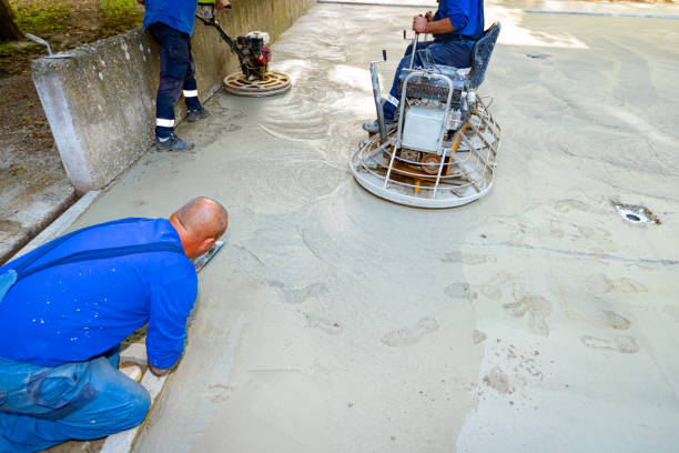 mason sta usando lo strumento per rifinire la superficie della lastra di cemento accanto alla cazzuola di potenza con motore - trowel power concrete finishing foto e immagini stock