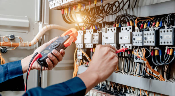 l’ingénieur électricien utilise un multimètre pour tester l’installation électrique et le courant de ligne électrique dans une armoire de commande du système électrique. - electro photos et images de collection