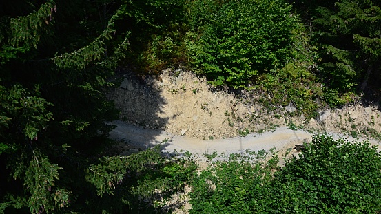 Aerial detail of downhill mountain bike track through coniferous forest during summer season. Location Kubinska Hola, northern Slovakia, central Europe.