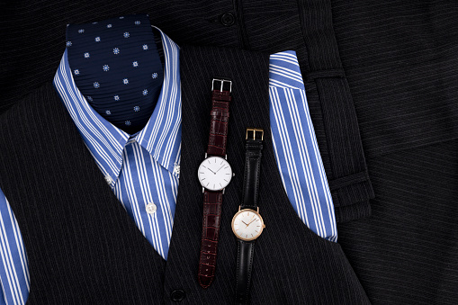Two dress watches on man dress composition with shirt and necktie