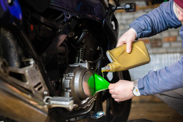 istock pouring new engine oil into a motorcycle engine. 1469657893