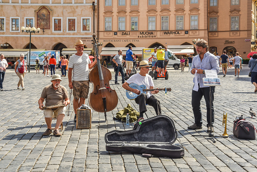 Group of street musicans holding a washboard, guitar and cello entertaining tourists on the main square in Prague. 4 juli 2026, Praque, Czech Republic