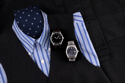 Two dress watches on man dress composition with shirt and necktie