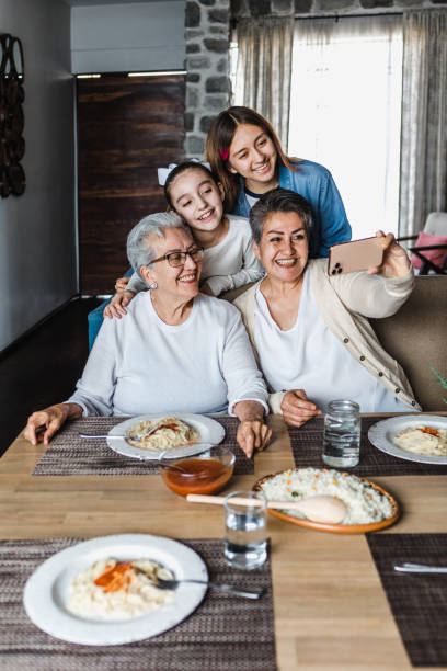 latynoskie kobiety wielopokoleniowe pozowanie rodzinne do zdjęcia selfie w porze kolacji w domu razem w ameryce łacińskiej - dining table child grandparent grandchild zdjęcia i obrazy z banku zdjęć