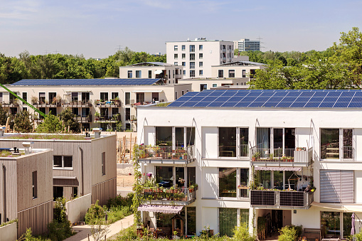 Munich, Bavaria, Germany - 05.19.2022: Eco City with Solar Energy of Residential Low-rise Apartment Buildings and Landscaping. Solar panels on Roof  of High-rise Modern House, Solar Balcony