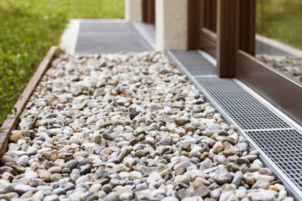 pavimento di ghiaia con pietre di drenaggio, sistema di superficie di drenaggio per l'acqua piovana intorno alla casa perimetrale - trincea foto e immagini stock