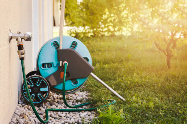 istock Garden Hose Coil Connected to External Faucet on Wall 1469662323