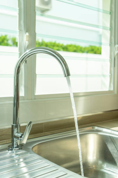 istock Water running from tap in kitchen sink. 1469662376