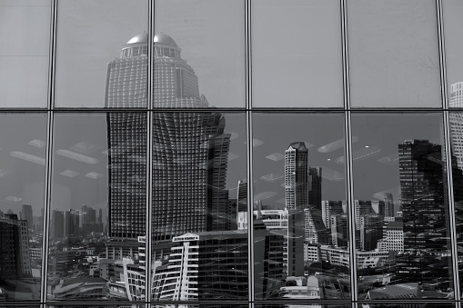 Bangkok modern skyline reflected on a glass facade, Thailand.