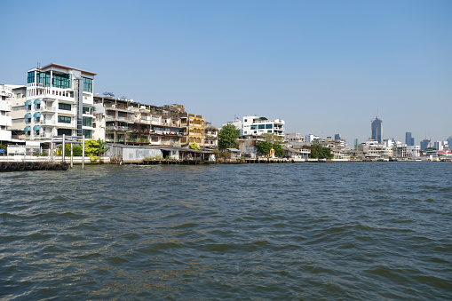 Old residential buildings on the Chao Phraya river waterfront, Bangkok, Thailand.