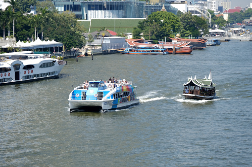 Modern and old tourboats riding on Chao Phraya river in Bangkok, Thailand.