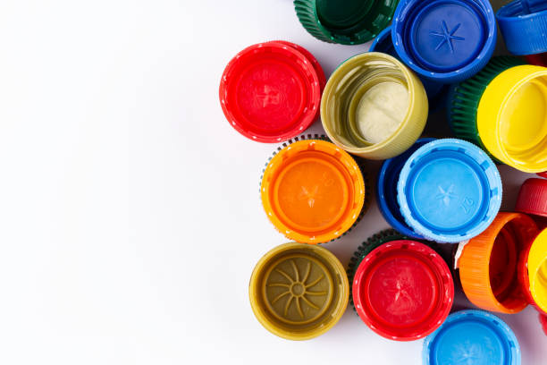istock Multicolored plastic bottle caps are scattered on a white background. Plastic recycle place for text. 1469666759