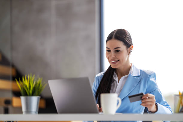 istock Businesswoman holding credit card and using laptop computer 1469668021