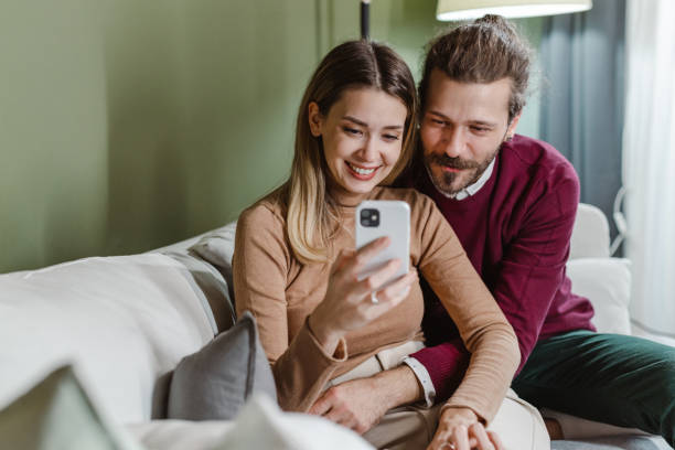istock Beautiful couple using smart phone at home 1469669448